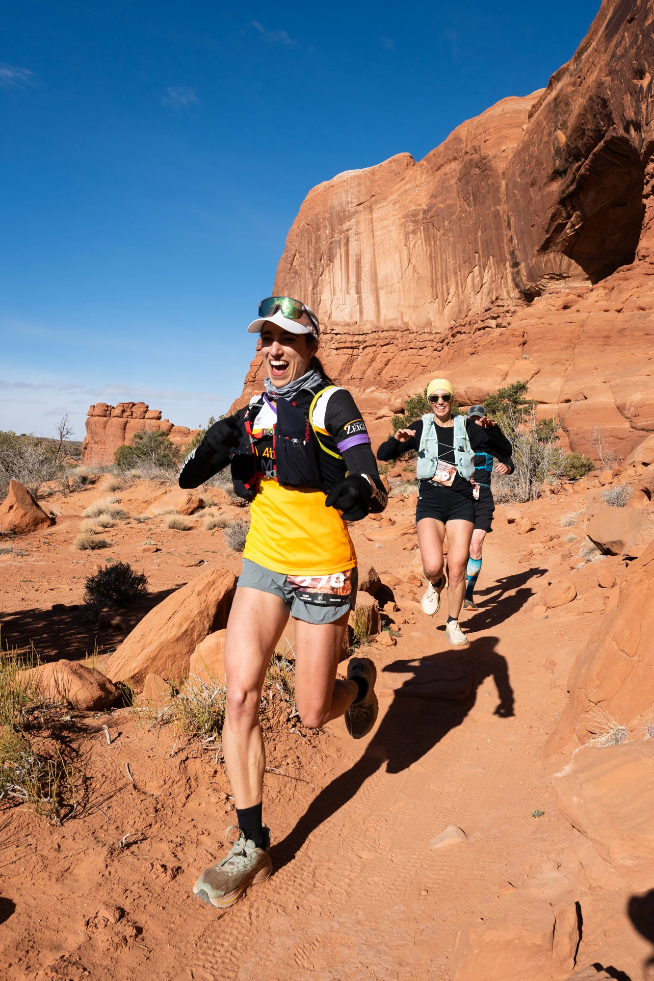 Two runners descend a red-rock trail during a TransRockies event.